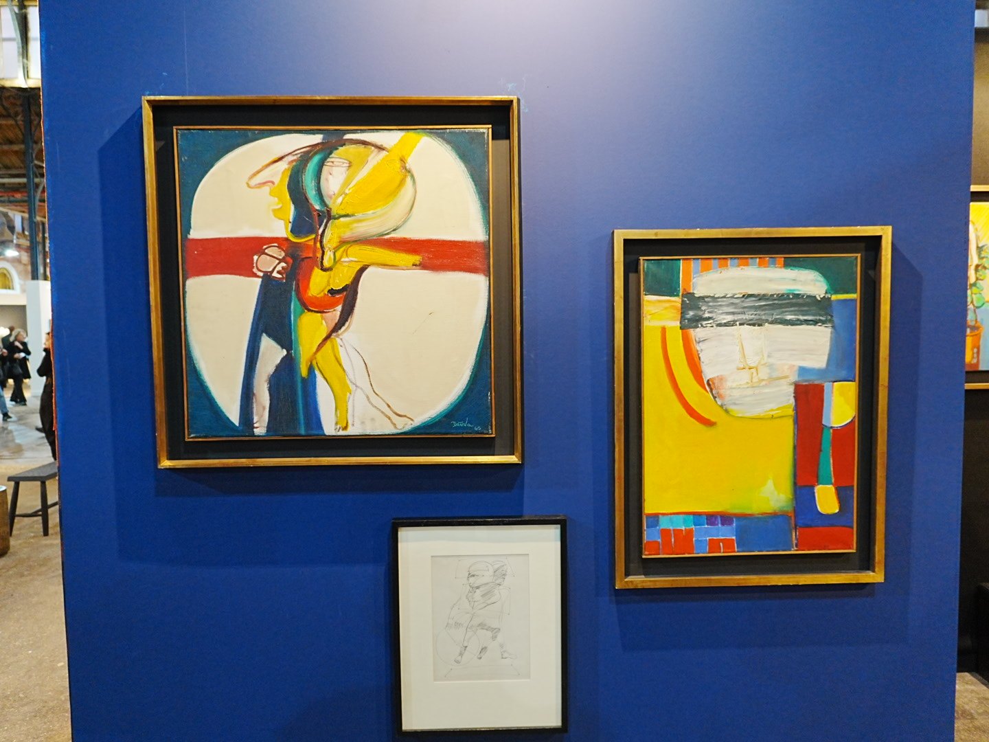 Pinturas exhibidas sobre una pared azul en MAPA 2026.