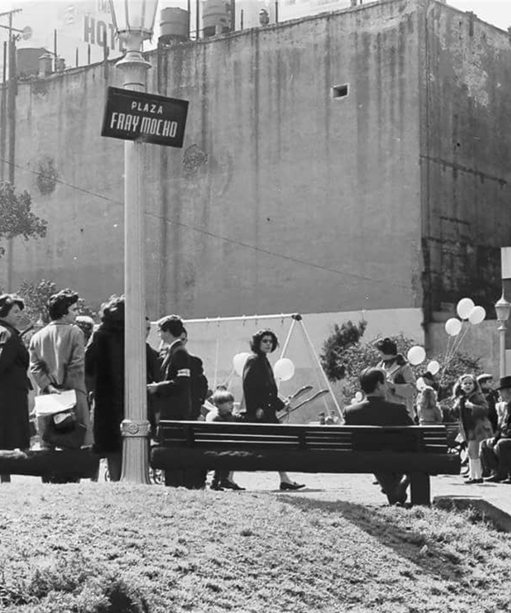 Plaza Fray Mocho, en Retiro, hacia 1960: gente con globos entre bancos, faroles y una medianera, fotografiada por Sameer Makarius.