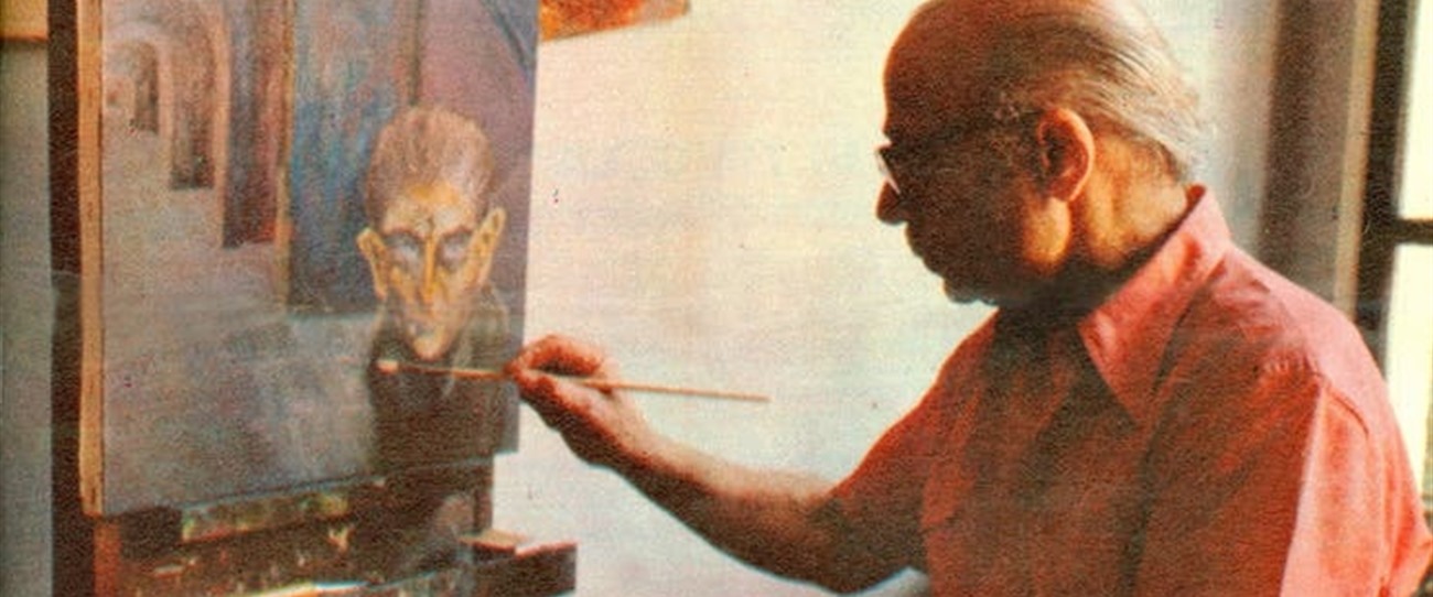 Ernesto Sábato, de camisa naranja, pintando un rostro sobre un caballete en su taller.
