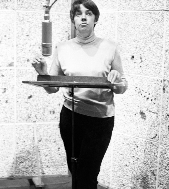 María Elena Walsh frente a un micrófono en un estudio de grabación.
